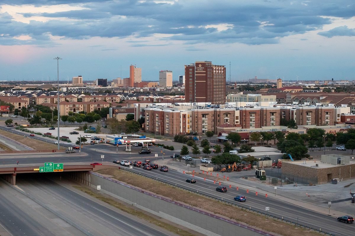 Downtown Lubbock at dusk, seen across an interstate, low buildings spread over flat plains