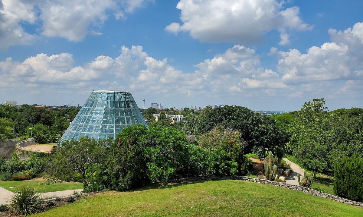 The glass conservatory of the San Antonio Botanical Garden, with the downtown skyline on the horizon